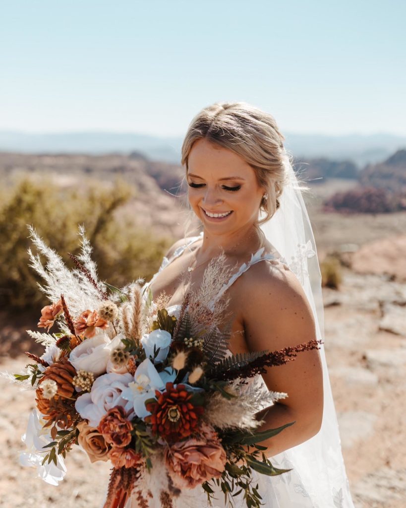Utah bride smiles with her stunning boho bouquet. Bailey said I do during her destination wedding in St. George, Utah.