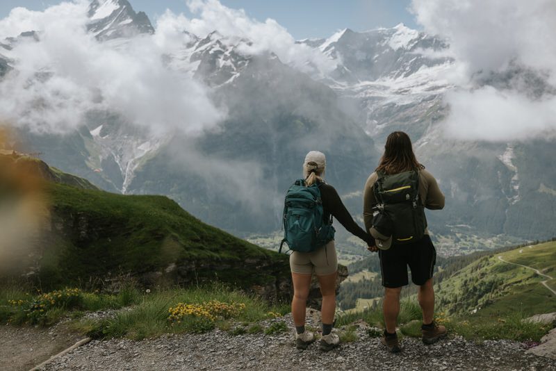Couple holding hands looking at mountain in Switzerland.