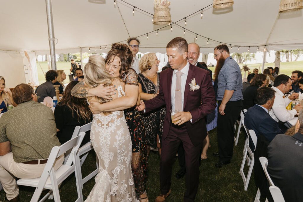 bride-and-groom-hugging-family